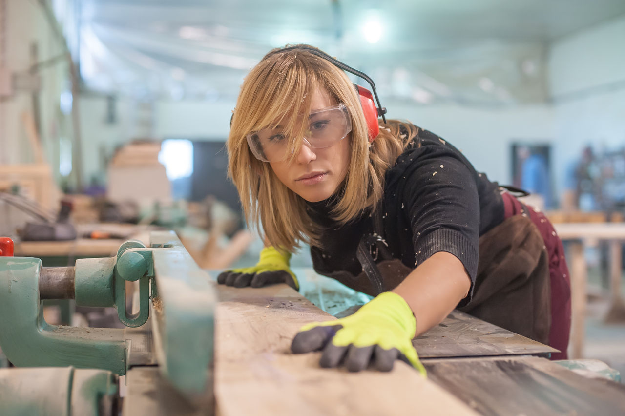 Female carpenter Using Electric Sander / Female carpenter Using Electric Sander for wood