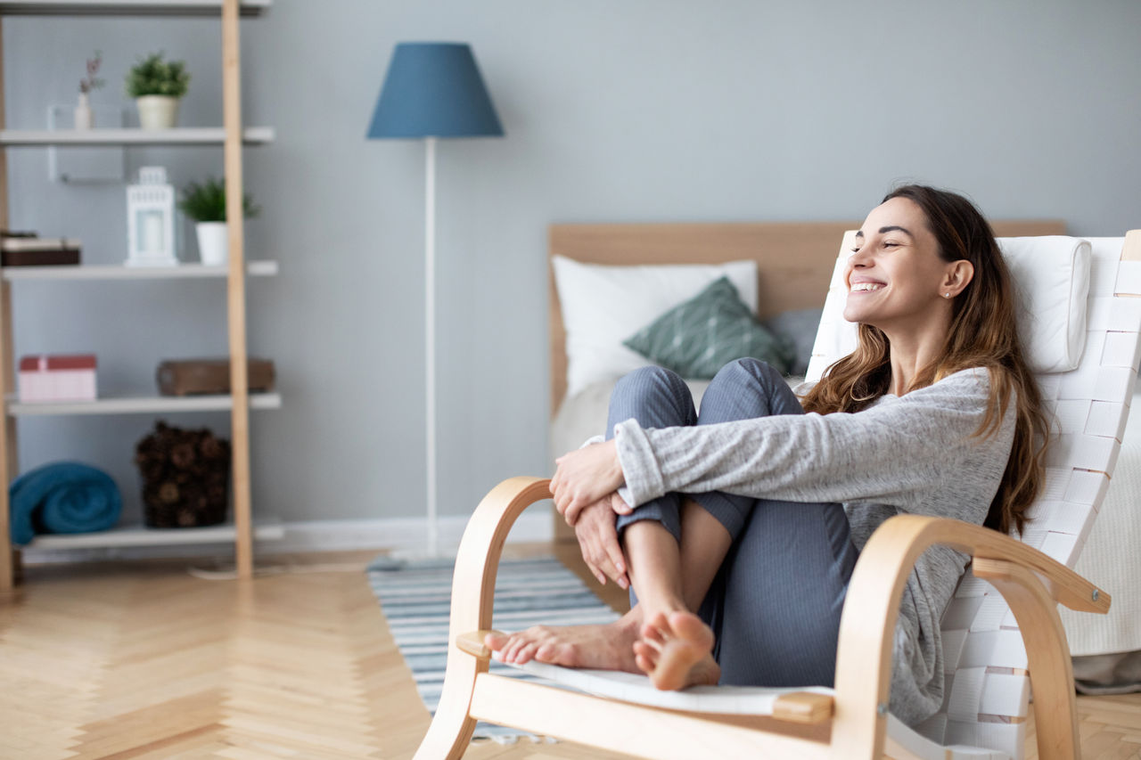 Woman relaxing in cozy chair at home. Lifestyle female portrait.